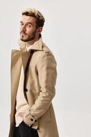 bello uomini nel beige cappotto modello maglione leggero sfondo foto