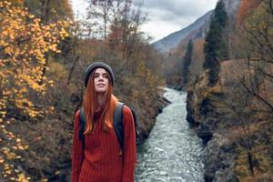 donna escursionista con zaino nel il montagne autunno foresta fiume paesaggio foto