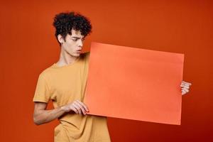 tipo con Riccio capelli Tenere un' rosso copia spazio manifesto foto