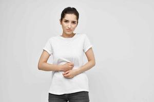 donna nel bianca maglietta Tenere sua stomaco diarrea dolore Salute i problemi foto
