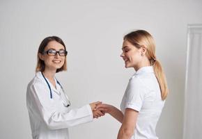 un' donna nel un' maglietta è venuto per vedere un' medico nel un' medico toga foto