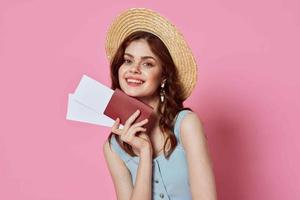 donna con cappello passaporto e aereo biglietto aeroporto passeggeri rosa sfondo foto