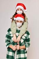 uomo e donna nel Natale cappelli abbraccio vacanza medico maschere foto