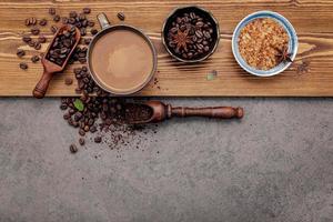 chicchi di caffè tostati con una tazza di caffè su uno sfondo di pietra scura