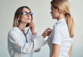 Salute i problemi femmina paziente e professionale medico bicchieri modello stetoscopio foto