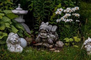 verde giardino con fiori e gesso figurina naturale sfondo foto
