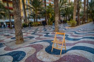 spiegato lungomare nel alicante Spagna punto di riferimento con di legno vuoto sedia su mosaico foto