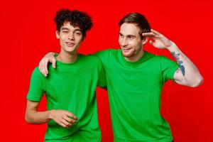 Due uomo verde magliette abbraccio emozioni amicizia rosso sfondo foto