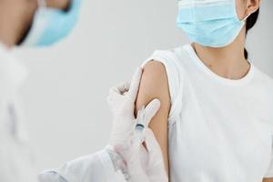 medico dando iniezione per donna di spalla avvicinamento vaccinazione laboratorio infezione foto