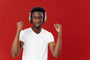 uomo di africano aspetto nel cuffia. musica amante stile di vita rosso sfondo foto