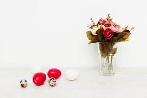 rosso uova Pasqua vacanza di il risurrezione di Cristo e un' mazzo di fiori nel un' vaso foto