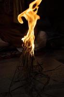 un' falò ardente a notte tempo con enorme giallo fiamma. falò festa con gli amici, a notte volta. enorme fuoco di bivacco con ardente boschi e buio notte sfondo. enorme giallo fiamma su un' buio notte. foto