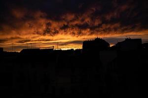 cielo sfondo con nuvole dopo tramonto al di sopra di buio tetti foto