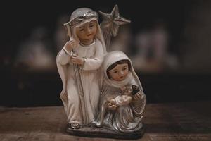 ceramica figurine di il madre di Dio Giuseppe e bambino Gesù per il Natività scena su un' buio Marrone sfondo foto