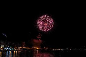 fuochi d'artificio mostrare a notte su il sponde di il mare di alicante Spagna foto