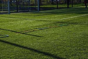 formazione calcio intonazione con artificiale verde erba e formazione AIDS illuminato di il pomeriggio sole foto