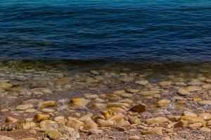 calma dolce sfondo di blu mare e riva con beige pietre foto