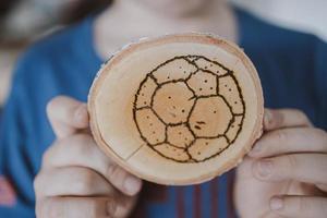 fatto a mano legna tampone con bruciato su calcio palla foto