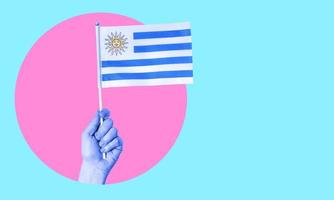 un' collage di moderno arte. femmina mano Tenere il bandiera di Uruguay nel un' cerchio, neon sfondo, con spazio per testo. foto