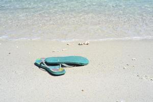 primo piano paio di vecchi sandali sulla spiaggia di sabbia bianca foto