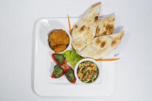 pollo harialy kabab, pollo tikka masala curry, indiano stile mescolare verdura , pianura nan e verde insalata piatto. foto