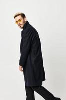 bello uomo con bicchieri nero cappotto moda moderno stile leggero sfondo foto