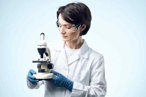femmina medico con microscopio nel mani tecnologia ricerca scienza foto