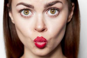 avvicinamento ritratto di donna soffiaggio bacio rosso labbra foto