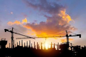 sagome di edificio costruzione luogo e costruzione gru con tramonto sfondo foto
