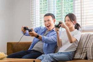 asiatico padre e figlia giocando video Giochi a casa, persone fare attività e famiglia concetti foto