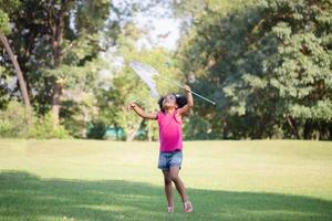 carino poco ragazzo ragazza giocando all'aperto nel il giardino, nero bambino ragazza nel il parco foto