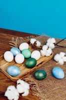 dipinto Pasqua uova su di legno tavola verbena fiori vacanza blu sfondo foto