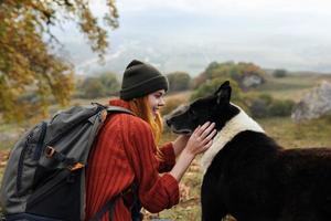 donna turista zaino giocando con cane viaggio amicizia foto