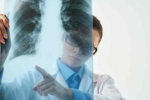 femmina medico medico viso maschera ricerca raggi X di paziente foto