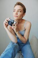 donna fotografo tiro nel studio su vecchio film telecamera a casa su divano ritratto, bianca sfondo, gratuito copia spazio, libero professionista fotografo foto