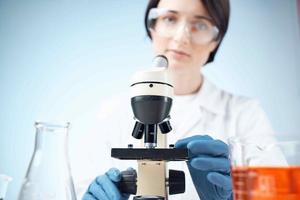 donna scienziato guardare attraverso un' microscopio laboratorio ricerca diagnostica foto