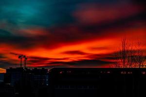 pittoresco paesaggio con tramonto con costruzione gru su il orizzonte foto