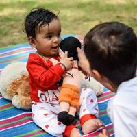 Due contento ragazzi nel società parco, contento asiatico fratelli chi siamo sorridente felicemente insieme. fratelli giocare all'aperto nel estate, migliore gli amici. bambino piccolo bambino ragazzo giocando con il suo contento fratello nel il giardino foto