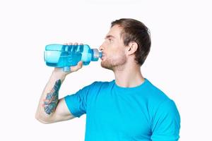 sexy atleti con un' bottiglia di acqua e nel un' blu maglietta su un' bianca sfondo bevanda foto