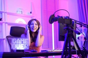 giovane asiatico bella donna professionista gamer avere vivere streaming , cantando e chat con sua fan a casa foto
