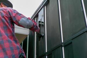 movimento sfocata mano del lavoratore dipingere la recinzione in acciaio. concetto di riparazione e manutenzione foto