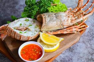 fresco aragosta o roccia aragosta frutti di mare con erba e spezie Limone coriandolo prezzemolo lattuga insalata, coperto di spine aragosta cibo su piatto, aragosta per cucinando cibo e frutti di mare salsa foto