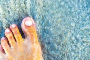 a piedi a piedi nudi su il spiaggia sabbia di il acqua Messico. foto