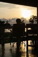 silhouette donne persona rilassare solo su un' sedia e godere tropicale natura nel il mattina con caffè volta, vacanza vacanza, vita la libertà concetto. foto