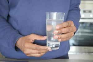 sporco acqua scrosciante a partire dal un' rubinetto rubinetto nel un' bicchiere, foto