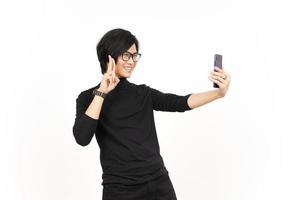 prendere un' autoscatto utilizzando smartphone di bello asiatico uomo isolato su bianca sfondo foto