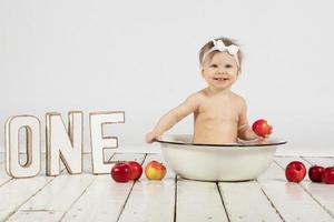 bellissimo bambino bagna nel un' bacino. uno anno vecchio bambino su il suo primo compleanno. foto