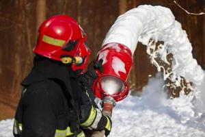 i vigili del fuoco spegnere un' fuoco. i soccorritori con fuoco tubi con schiuma. foto