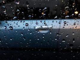 gocce di pioggia spruzzi su il auto finestra foto