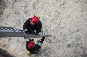 pompiere si arrampica il scale. Bagnino addestramento. foto